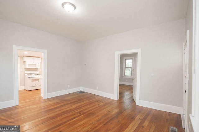 unfurnished bedroom with wood-type flooring, baseboards, and visible vents