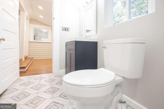 bathroom with vanity, toilet, and baseboards