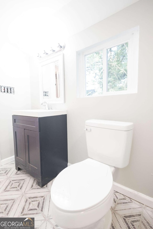 bathroom featuring tile patterned floors, baseboards, vanity, and toilet