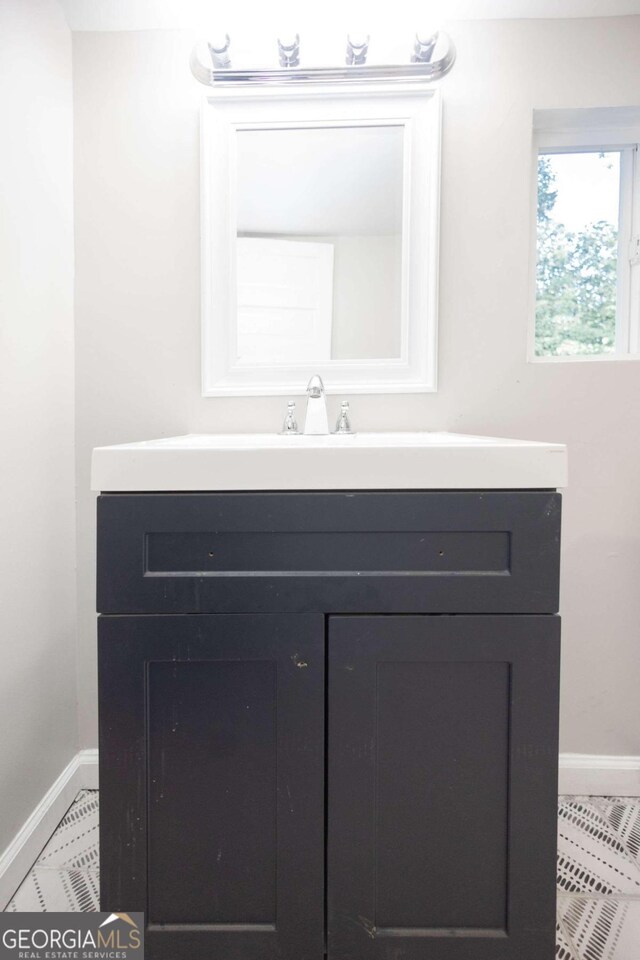 bathroom with tile patterned flooring, baseboards, and vanity