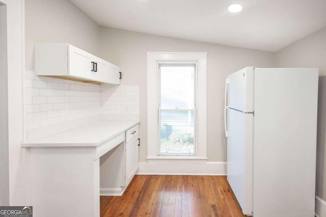 kitchen featuring backsplash, vaulted ceiling, dark wood-type flooring, white cabinets, and white refrigerator