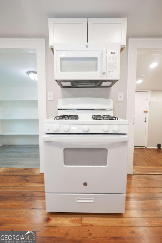 kitchen featuring hardwood / wood-style flooring, white cabinets, and white appliances