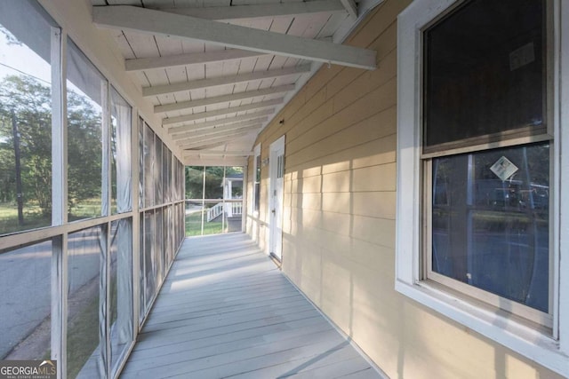 unfurnished sunroom featuring lofted ceiling with beams and wood ceiling