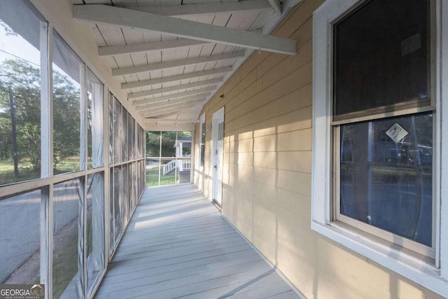 unfurnished sunroom featuring beam ceiling