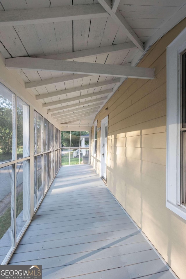 exterior space featuring vaulted ceiling with beams, wood ceiling, and a healthy amount of sunlight