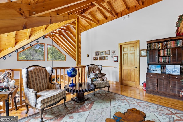 sitting room with wooden ceiling, beam ceiling, high vaulted ceiling, and light wood-type flooring