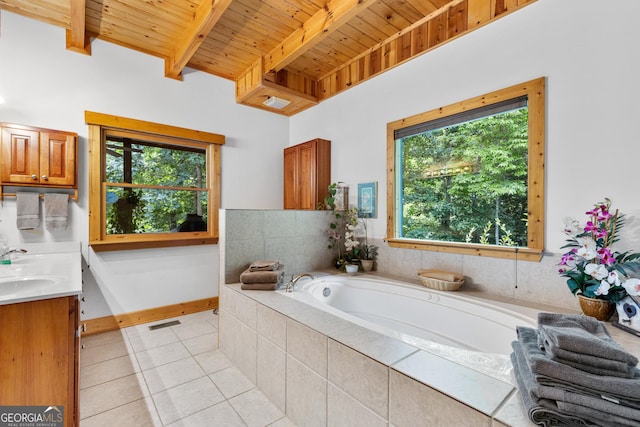 bathroom with tile patterned floors, wood ceiling, vanity, tiled tub, and beamed ceiling