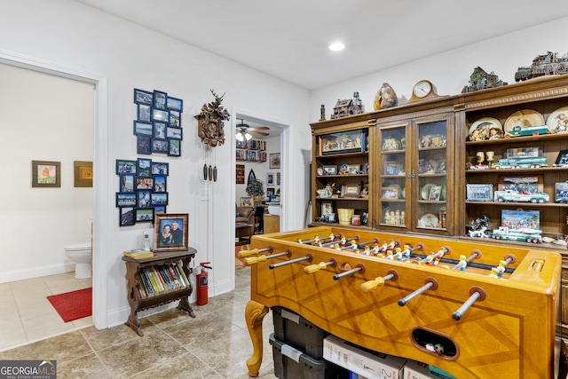 recreation room featuring light tile patterned floors and ceiling fan