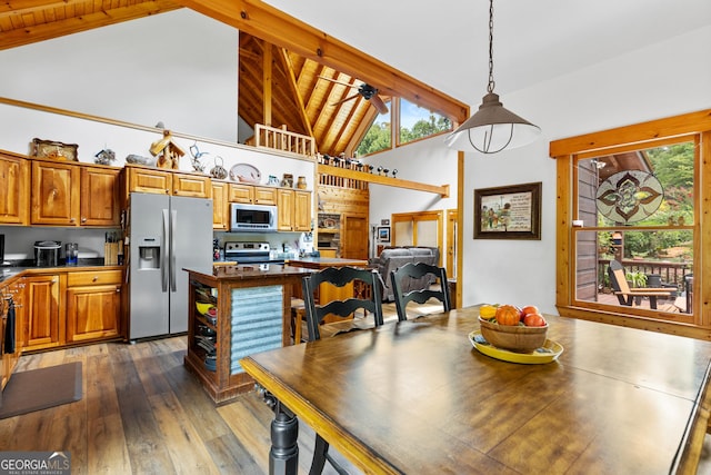 dining space with plenty of natural light, high vaulted ceiling, dark hardwood / wood-style floors, and beamed ceiling