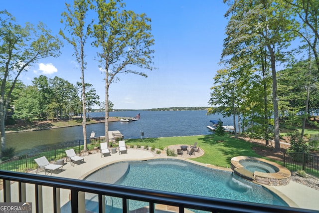 view of swimming pool featuring a lawn, a water view, a patio area, and an in ground hot tub