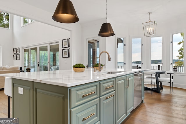 kitchen featuring a kitchen island with sink, plenty of natural light, and sink