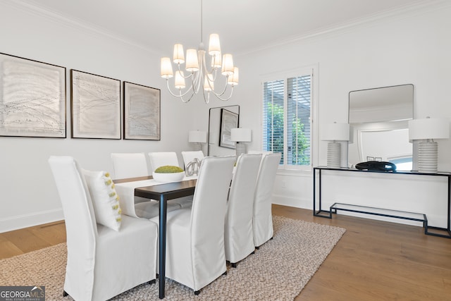 dining area featuring an inviting chandelier, hardwood / wood-style flooring, and crown molding