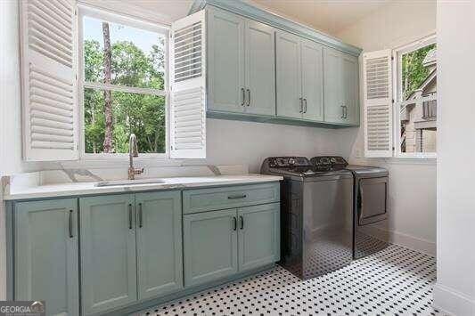 washroom with cabinets, sink, and washer and dryer