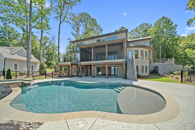 view of swimming pool with a sunroom, a patio, and pool water feature