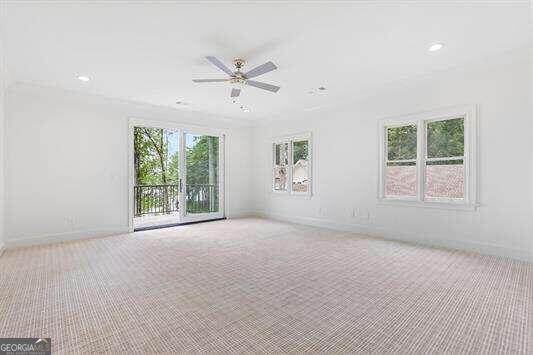 spare room with light carpet, ceiling fan, and a healthy amount of sunlight