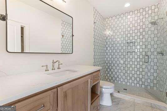 bathroom with vanity, toilet, and a shower with shower door