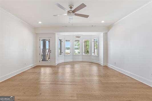 unfurnished living room with ornamental molding, ceiling fan, and hardwood / wood-style flooring