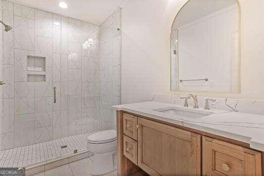 bathroom featuring walk in shower, vanity, and toilet