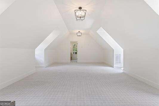 bonus room featuring lofted ceiling and light colored carpet