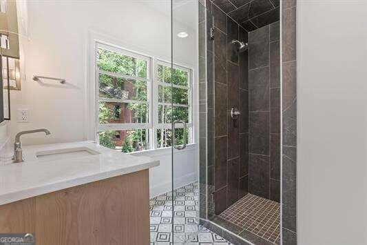 bathroom featuring walk in shower and vanity