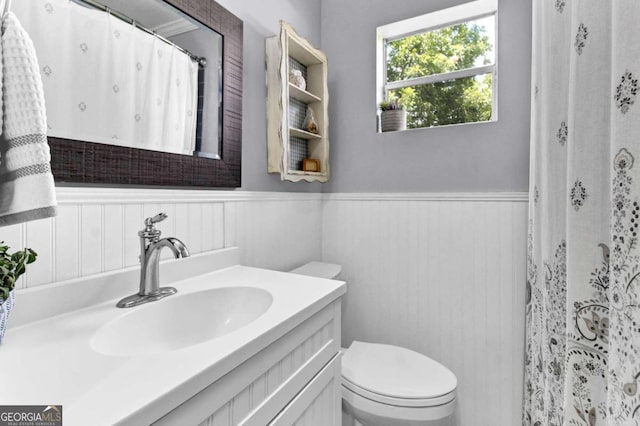 bathroom with vanity, a shower with shower curtain, and toilet