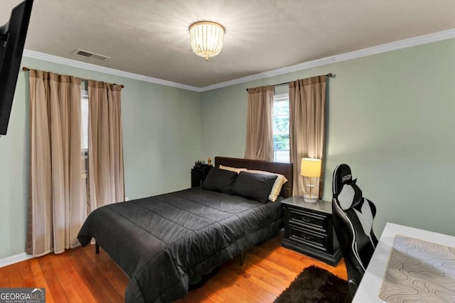 bedroom featuring ornamental molding and wood-type flooring