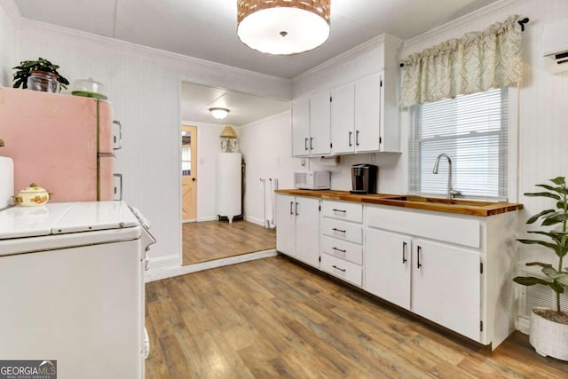 kitchen featuring sink, white appliances, white cabinets, and light wood-type flooring