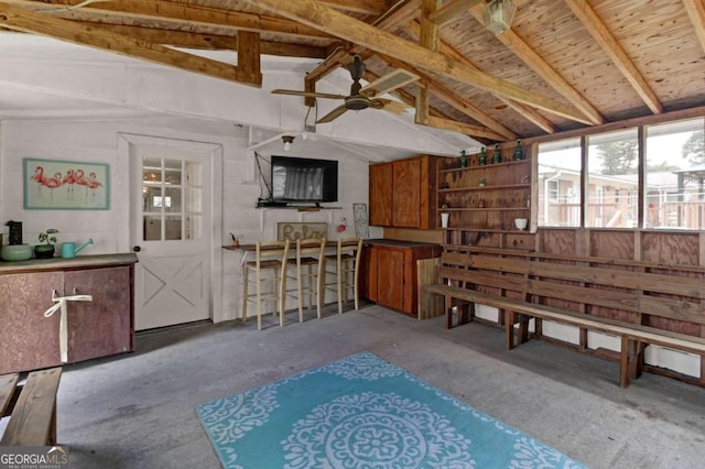 miscellaneous room featuring vaulted ceiling with beams, concrete floors, and ceiling fan