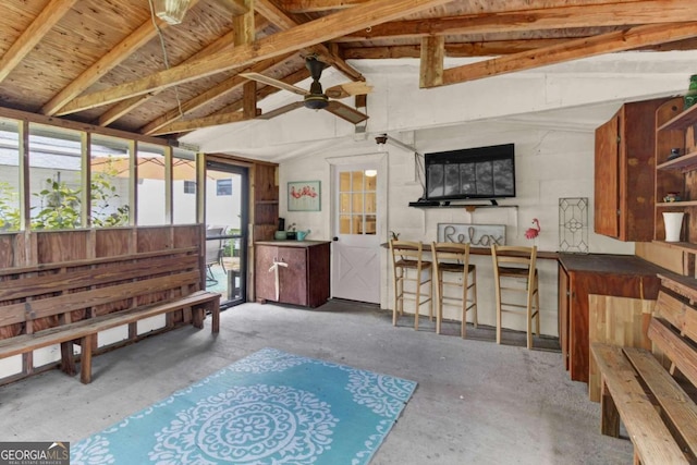 misc room with ceiling fan, concrete floors, and vaulted ceiling with beams