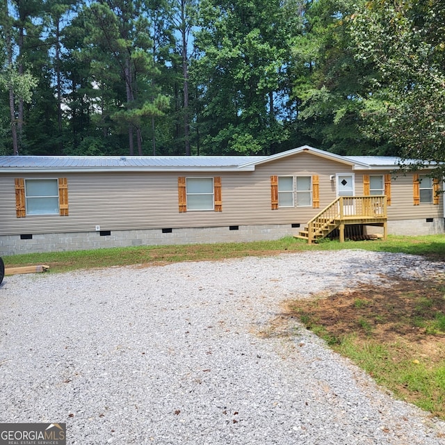 view of front facade with metal roof, crawl space, and driveway