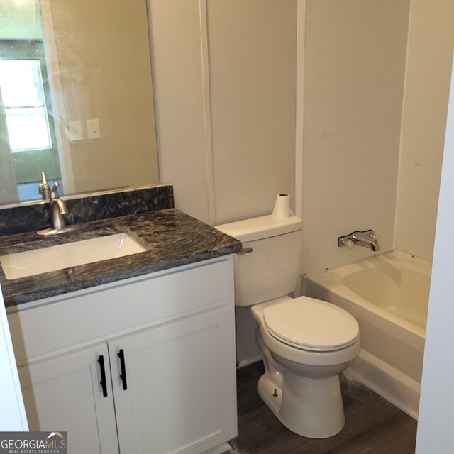 full bathroom with toilet,  shower combination, wood finished floors, and vanity