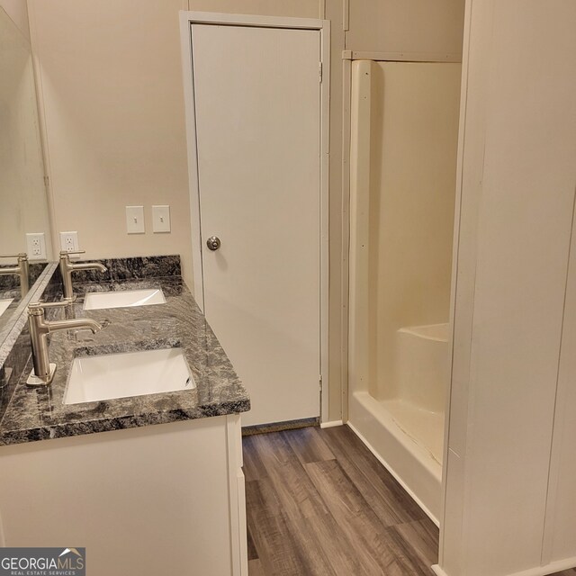 bathroom featuring double vanity, a sink, and wood finished floors