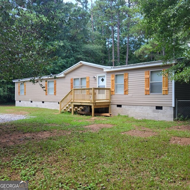 manufactured / mobile home featuring a front lawn, crawl space, and a wooden deck