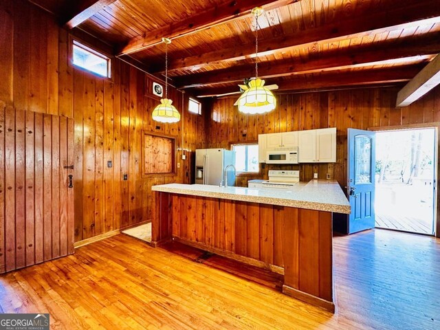 kitchen featuring beamed ceiling, white appliances, wood ceiling, light wood-type flooring, and wood walls