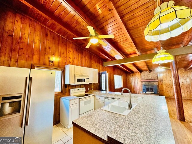 kitchen featuring a fireplace, vaulted ceiling with beams, white appliances, wood walls, and wood ceiling