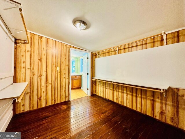 unfurnished room with wood-type flooring and wooden walls