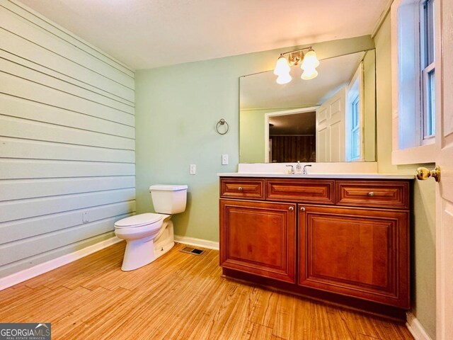 bathroom featuring vanity, a notable chandelier, toilet, and hardwood / wood-style flooring