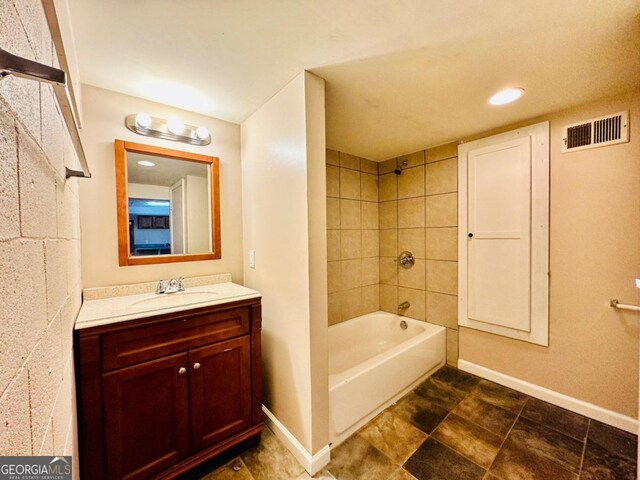 bathroom with tile patterned floors, tiled shower / bath combo, and vanity