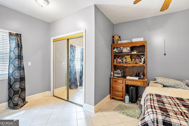 bedroom with light tile patterned floors, ceiling fan, and a closet