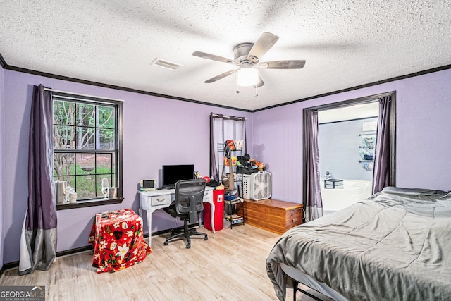 bedroom featuring ceiling fan, ornamental molding, light hardwood / wood-style flooring, and a textured ceiling