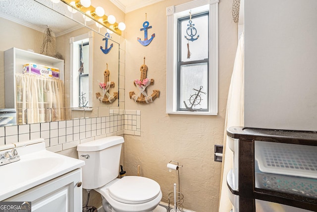 bathroom with crown molding, vanity, toilet, and decorative backsplash