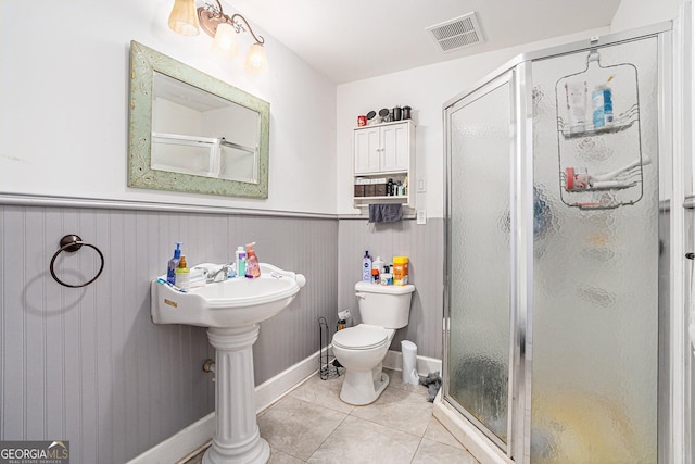 bathroom with walk in shower, toilet, and tile patterned flooring