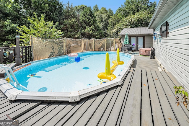 view of pool featuring a wooden deck and an outdoor structure