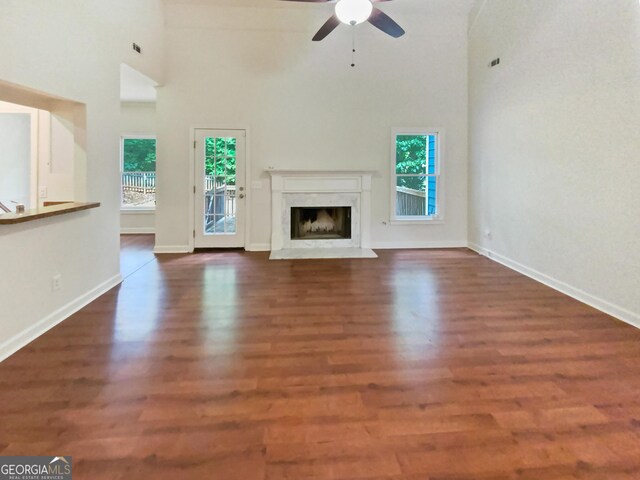 unfurnished living room with a fireplace, a healthy amount of sunlight, hardwood / wood-style floors, and ceiling fan