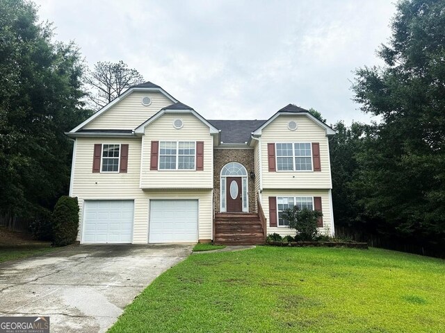 bi-level home featuring a garage and a front yard