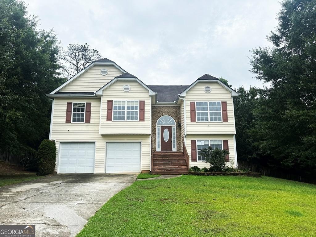 split foyer home featuring a garage and a front lawn