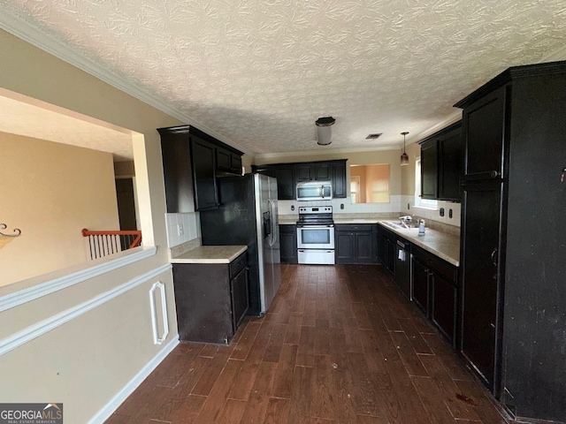 kitchen featuring electric range oven, hanging light fixtures, crown molding, a textured ceiling, and dark hardwood / wood-style floors