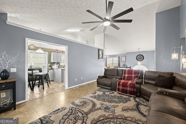 living room with a healthy amount of sunlight, a textured ceiling, light tile patterned floors, and lofted ceiling