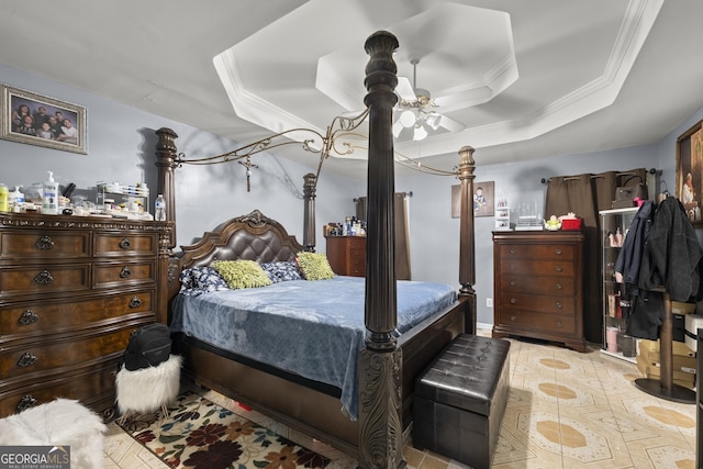 bedroom featuring ceiling fan, a tray ceiling, and ornamental molding