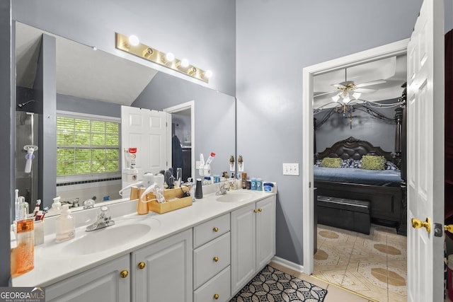 bathroom with ceiling fan, vaulted ceiling, vanity, and tile patterned flooring